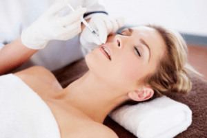 A blonde lady receiving lip fillers