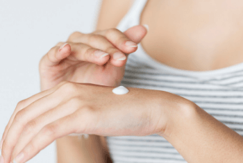 a female hand with skin cream on it